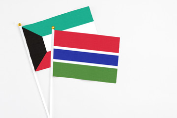 Gambia and Kuwait stick flags on white background. High quality fabric, miniature national flag. Peaceful global concept.White floor for copy space.