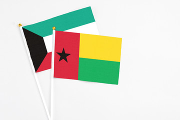 Guinea Bissau and Kuwait stick flags on white background. High quality fabric, miniature national flag. Peaceful global concept.White floor for copy space.