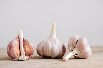 Garlic lie in a row on a rustic wooden background. Copy, empty space for text