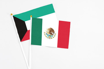 Mexico and Kuwait stick flags on white background. High quality fabric, miniature national flag. Peaceful global concept.White floor for copy space.