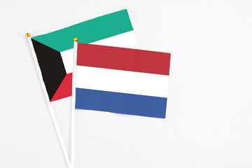 Netherlands and Kuwait stick flags on white background. High quality fabric, miniature national flag. Peaceful global concept.White floor for copy space.