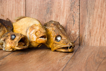 Smoked fish on an old wooden background. Pikeperch, Perch, Piranha. River fish.