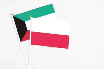 Poland and Kuwait stick flags on white background. High quality fabric, miniature national flag. Peaceful global concept.White floor for copy space.