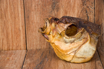 Smoked bream head on an old wooden background. River fish.