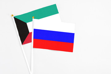 Russia and Kuwait stick flags on white background. High quality fabric, miniature national flag. Peaceful global concept.White floor for copy space.