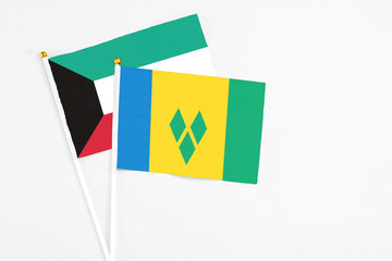 Saint Vincent And The Grenadines and Kuwait stick flags on white background. High quality fabric,...
