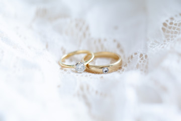 Diamond rings on white lace wedding dress