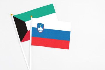 Slovenia and Kuwait stick flags on white background. High quality fabric, miniature national flag. Peaceful global concept.White floor for copy space.