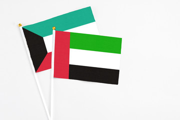 United Arab Emirates and Kuwait stick flags on white background. High quality fabric, miniature national flag. Peaceful global concept.White floor for copy space.