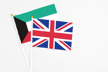 United Kingdom and Kuwait stick flags on white background. High quality fabric, miniature national flag. Peaceful global concept.White floor for copy space.