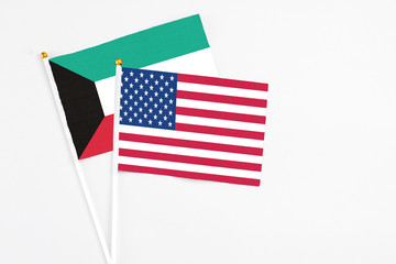 United States and Kuwait stick flags on white background. High quality fabric, miniature national flag. Peaceful global concept.White floor for copy space.