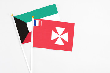 Wallis And Futuna and Kuwait stick flags on white background. High quality fabric, miniature...