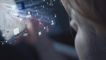 Young blonde woman looks at digital projection of data from her smartphone in a dark environment - Powered by Adobe