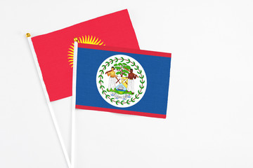 Belize and Kyrgyzstan stick flags on white background. High quality fabric, miniature national flag. Peaceful global concept.White floor for copy space.