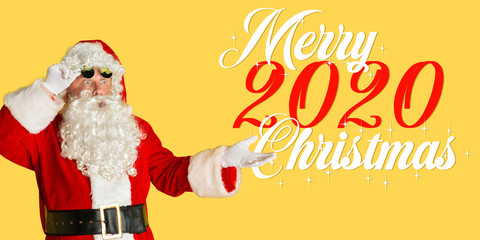 Santa Claus in sunglasses isolated on yellow studio background. Caucasian male model in traditional costume. Concept of Christmas, 2020 New Year's, winter mood. Copyspace. Astonished and shocked.
