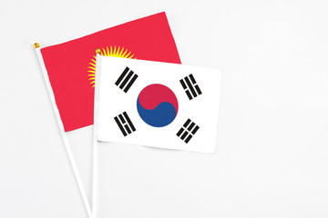 South Korea and Kyrgyzstan stick flags on white background. High quality fabric, miniature national flag. Peaceful global concept.White floor for copy space.