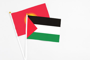 Palestine and Kyrgyzstan stick flags on white background. High quality fabric, miniature national...