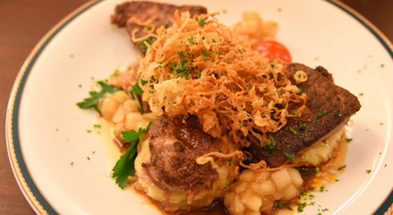 Wundervoll arrangierte Portion gebratene Rinderleber mit Kartoffelpüree und geschmorten Zwiebeln