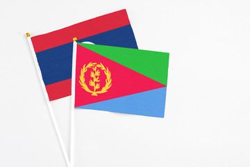 Eritrea and Laos stick flags on white background. High quality fabric, miniature national flag. Peaceful global concept.White floor for copy space.