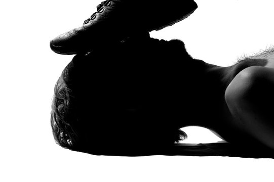 A silhouette photo on a white background, a foot in shoes is crushing on a face