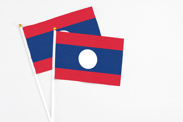 Laos and Laos stick flags on white background. High quality fabric, miniature national flag. Peaceful global concept.White floor for copy space.