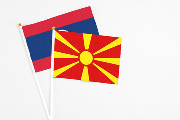 Macedonia and Laos stick flags on white background. High quality fabric, miniature national flag. Peaceful global concept.White floor for copy space.