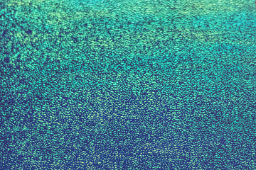 Background from holographic wrapping paper. Selective focus. Christmas background.