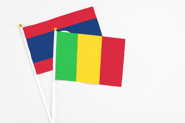 Mali and Laos stick flags on white background. High quality fabric, miniature national flag. Peaceful global concept.White floor for copy space.