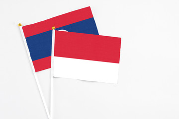 Monaco and Laos stick flags on white background. High quality fabric, miniature national flag. Peaceful global concept.White floor for copy space.