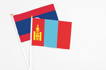 Mongolia and Laos stick flags on white background. High quality fabric, miniature national flag. Peaceful global concept.White floor for copy space.
