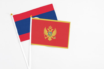 Montenegro and Laos stick flags on white background. High quality fabric, miniature national flag. Peaceful global concept.White floor for copy space.