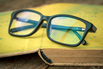Old book with  glasses