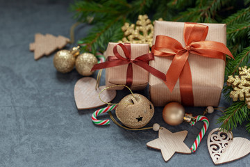 Christmas decorations. Two Gifts wrapped craft with fir branches and holiday decoration on dark gray background.