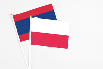 Poland and Laos stick flags on white background. High quality fabric, miniature national flag. Peaceful global concept.White floor for copy space.