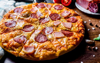 Pepperoni Pizza with Mozzarella cheese, salami, ham. Italian pizza on wooden table background