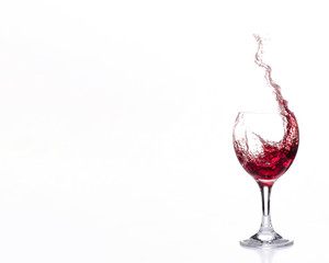 Roter Wein spritzt aus einem Weinglas