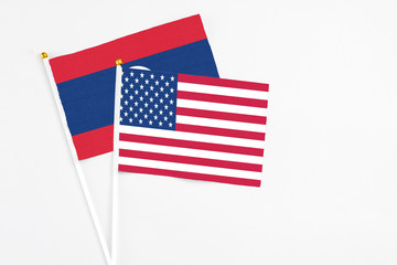 United States and Laos stick flags on white background. High quality fabric, miniature national flag. Peaceful global concept.White floor for copy space.