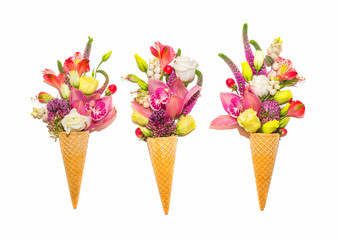 Waffle cones with flowers on white background