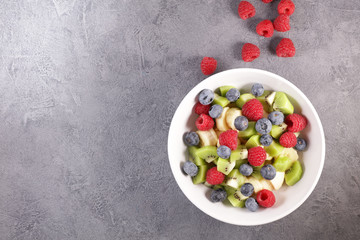 fresh fruit salad with banana, blueberry, kiwi and raspberry