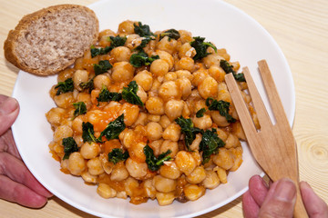 woman hands holding bowl of chickpeas with spinach