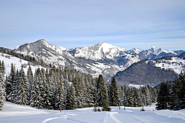 Fototapeta na wymiar Beautiful peaceful winter landscape in the Frence Alps, at one of the ski stations, France. The view on the empty ski slopes