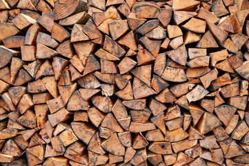 Stack of firewood. A lot of firewood stacked wall. Chopped wood.