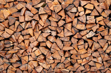 Stack of firewood. A lot of firewood is piled up by the wall.