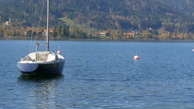 Lonely small boat at anchor in a beautiful picturesque mountain area on Lake Tegernsee, Bavaria against the backdrop of the beautiful bavarian alps