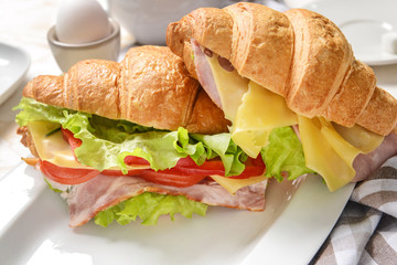Tasty croissant sandwiches on plate, closeup