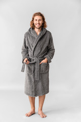 Portrait of handsome man in bathrobe on grey background