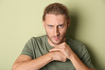 Portrait of aggressive man on color background