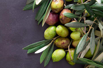natural olives with leaves on black background