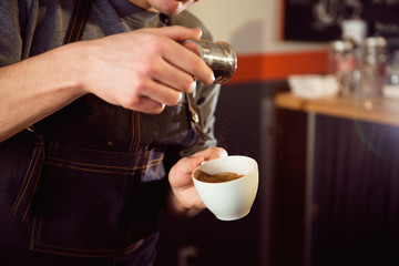 Coffee Latte Barista making pattern in a cup of coffee shop.