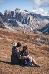 Fototapeta premium couple in love sitting in the Dolomites near Mount Sceda